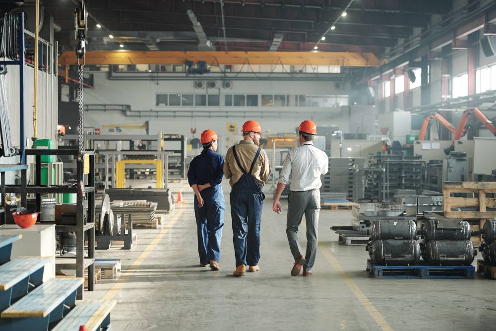 trois travailleurs d'une installation industrielle en train de marcher