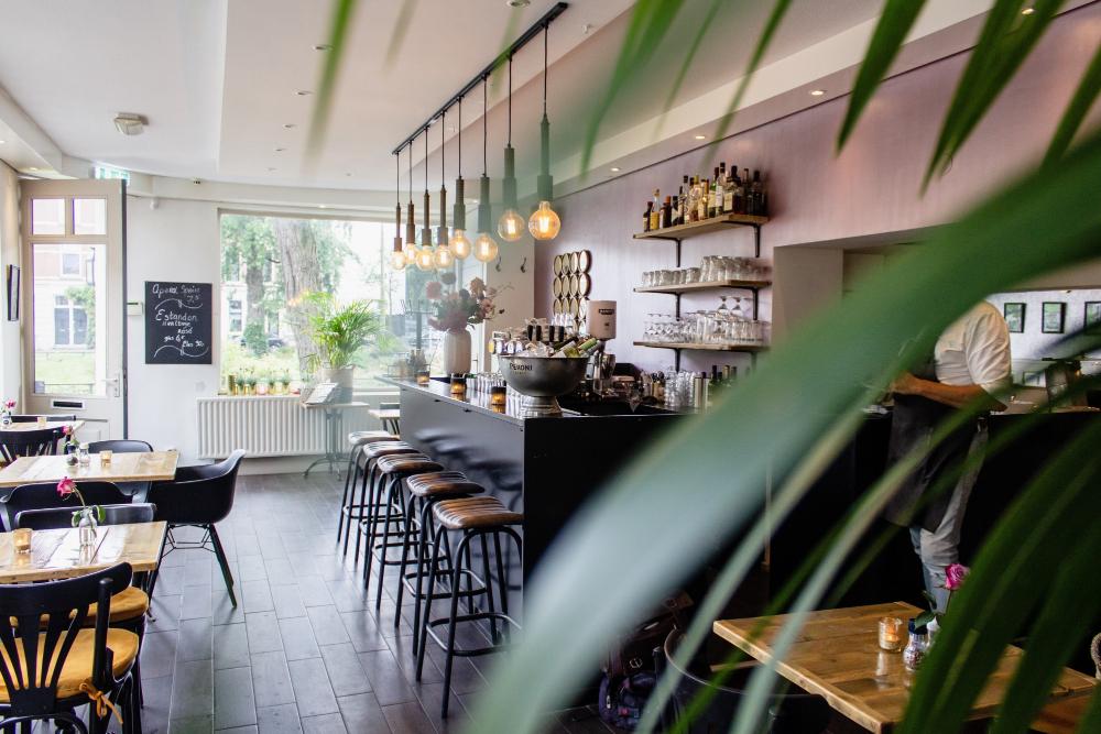 Vue intérieure d'un café avec des chaises près du bar et des tables en bois